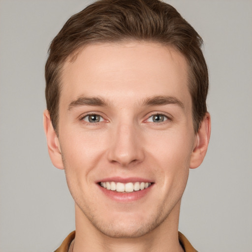 Joyful white young-adult male with short  brown hair and grey eyes