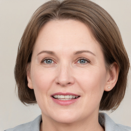 Joyful white adult female with medium  brown hair and grey eyes