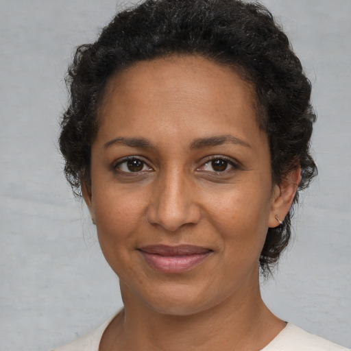 Joyful black adult female with short  brown hair and brown eyes