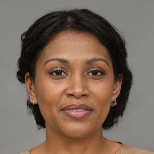 Joyful black adult female with medium  brown hair and brown eyes