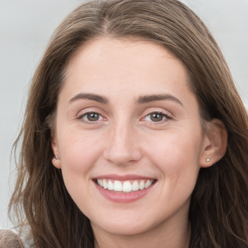 Joyful white young-adult female with long  brown hair and grey eyes