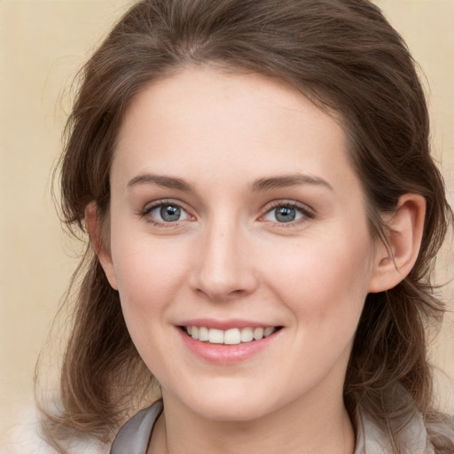 Joyful white young-adult female with medium  brown hair and grey eyes