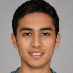 Joyful latino young-adult male with short  brown hair and brown eyes