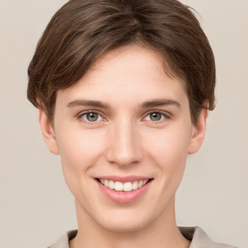 Joyful white young-adult female with short  brown hair and grey eyes