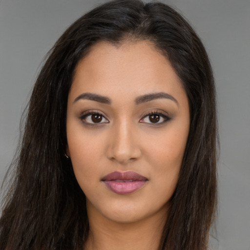 Joyful latino young-adult female with long  brown hair and brown eyes