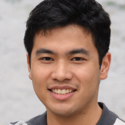 Joyful asian young-adult male with short  black hair and brown eyes
