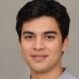 Joyful white young-adult male with short  black hair and brown eyes