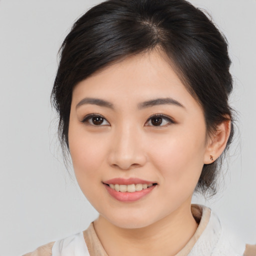 Joyful asian young-adult female with medium  brown hair and brown eyes