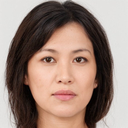 Joyful asian young-adult female with long  brown hair and brown eyes