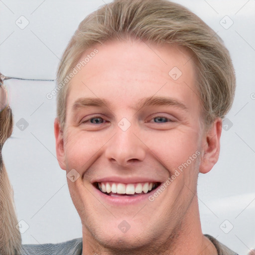 Joyful white young-adult male with short  brown hair and blue eyes