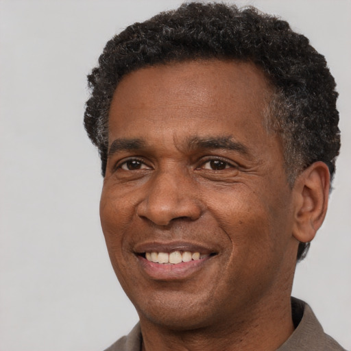 Joyful black adult male with short  brown hair and brown eyes