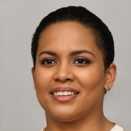 Joyful latino young-adult female with short  black hair and brown eyes