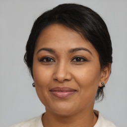 Joyful latino adult female with medium  brown hair and brown eyes