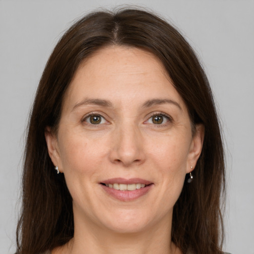 Joyful white adult female with long  brown hair and grey eyes