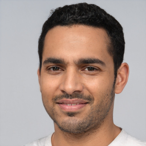 Joyful latino young-adult male with short  black hair and brown eyes