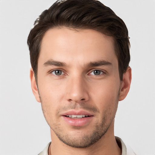 Joyful white young-adult male with short  brown hair and grey eyes