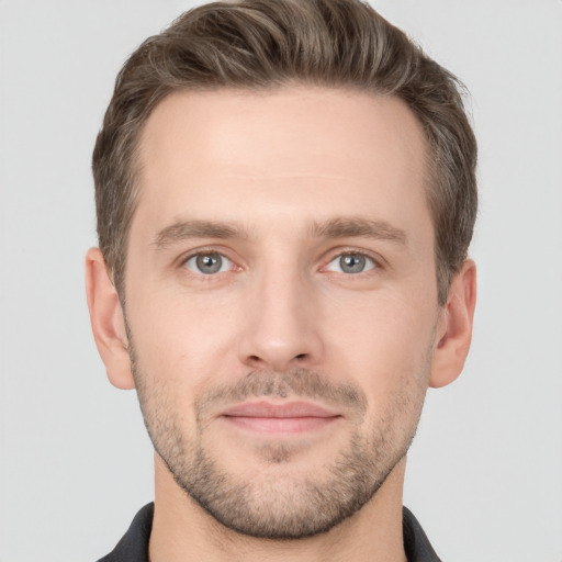 Joyful white young-adult male with short  brown hair and grey eyes