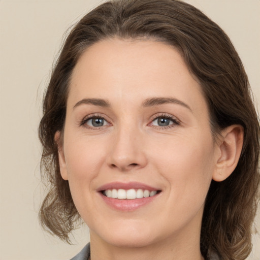 Joyful white young-adult female with medium  brown hair and grey eyes