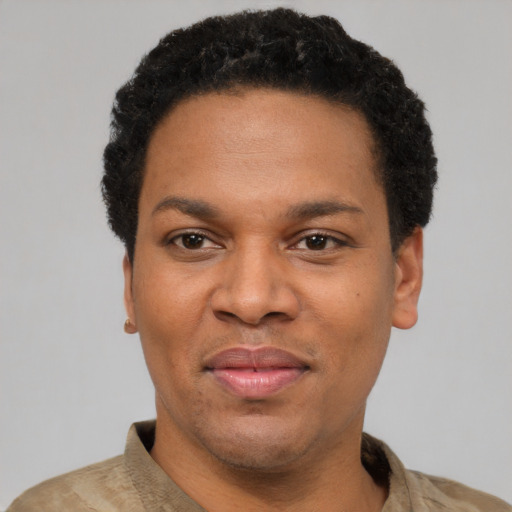 Joyful black adult male with short  black hair and brown eyes