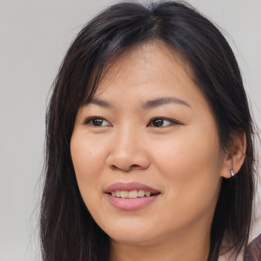 Joyful asian young-adult female with long  brown hair and brown eyes