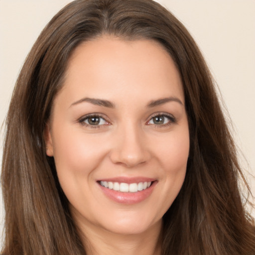 Joyful white young-adult female with long  brown hair and brown eyes