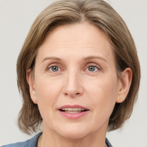 Joyful white adult female with medium  brown hair and grey eyes