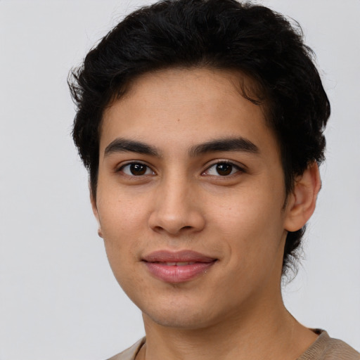 Joyful latino young-adult male with short  brown hair and brown eyes