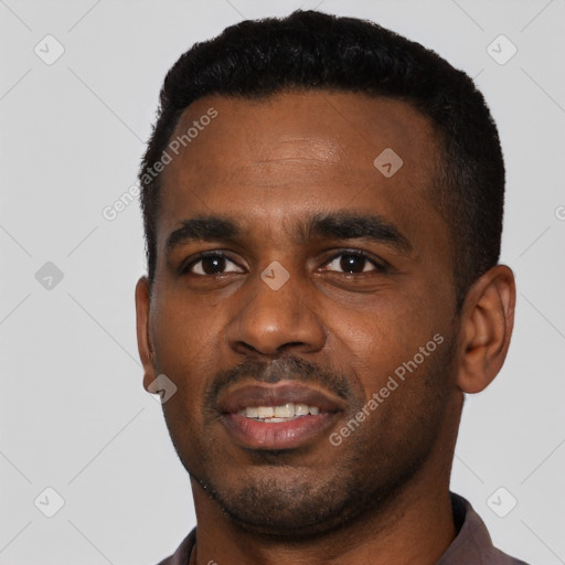 Joyful black young-adult male with short  black hair and brown eyes