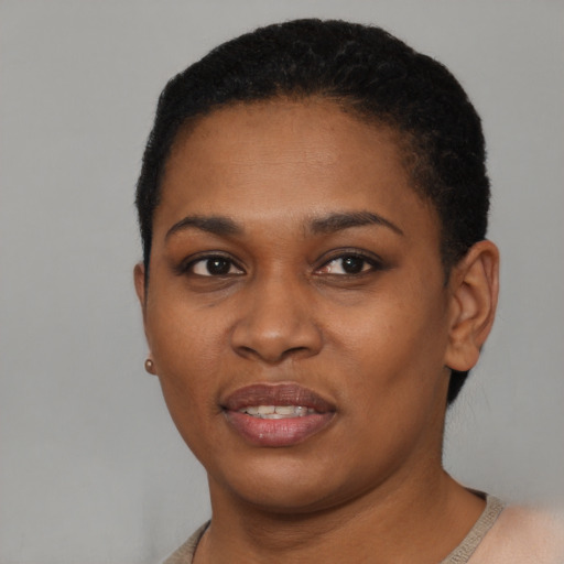 Joyful black young-adult female with short  black hair and brown eyes
