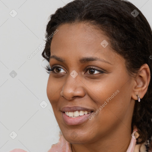 Joyful black young-adult female with long  brown hair and brown eyes