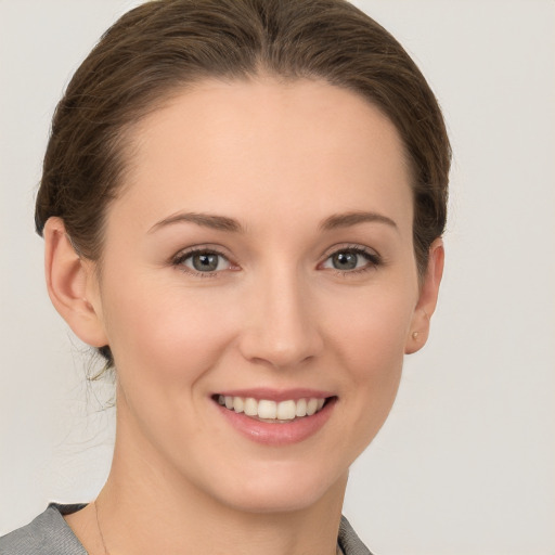 Joyful white young-adult female with medium  brown hair and grey eyes