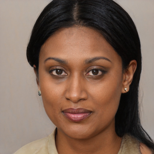 Joyful black young-adult female with long  brown hair and brown eyes