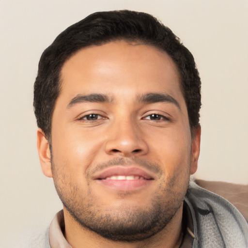 Joyful latino young-adult male with short  brown hair and brown eyes