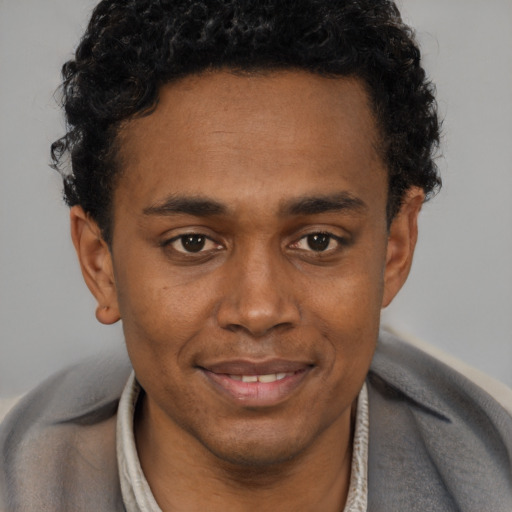 Joyful black young-adult male with short  brown hair and brown eyes