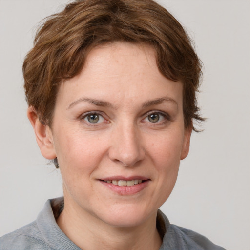 Joyful white young-adult female with short  brown hair and grey eyes