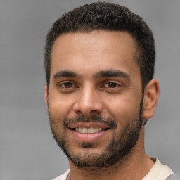 Joyful white young-adult male with short  black hair and brown eyes