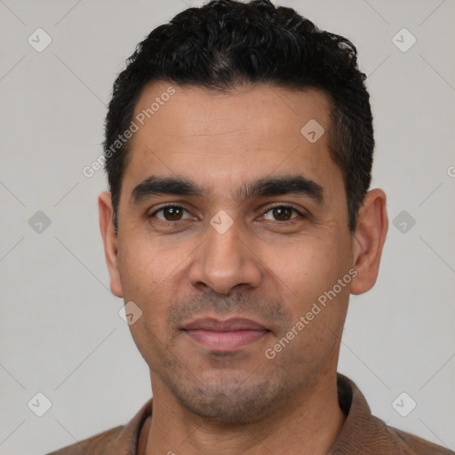 Joyful latino young-adult male with short  black hair and brown eyes