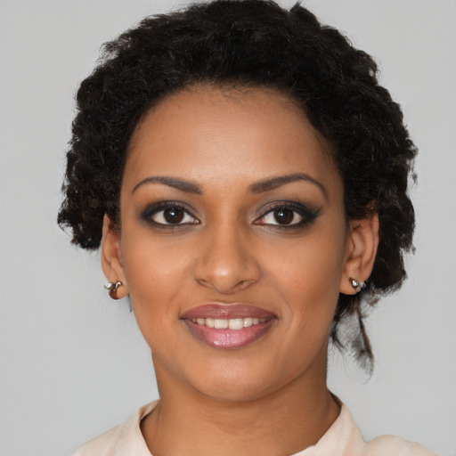 Joyful black young-adult female with medium  black hair and brown eyes