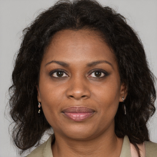 Joyful black adult female with medium  brown hair and brown eyes