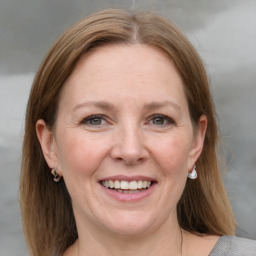 Joyful white adult female with medium  brown hair and grey eyes