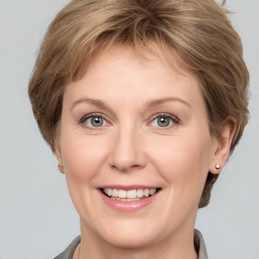 Joyful white adult female with medium  brown hair and grey eyes