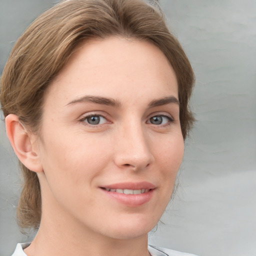 Joyful white young-adult female with medium  brown hair and grey eyes