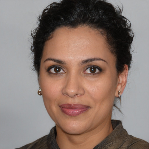 Joyful latino adult female with medium  brown hair and brown eyes