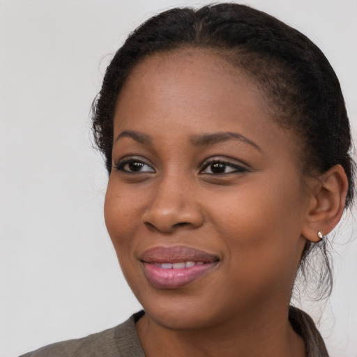 Joyful black young-adult female with long  brown hair and brown eyes