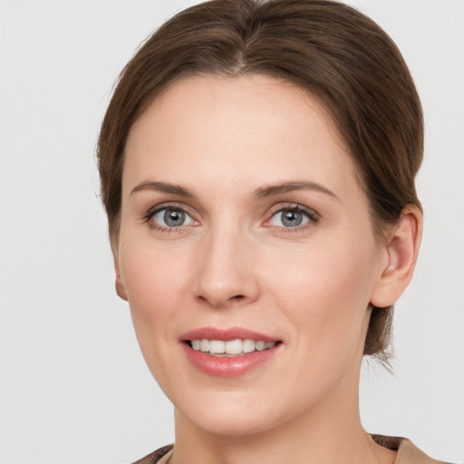 Joyful white young-adult female with medium  brown hair and grey eyes