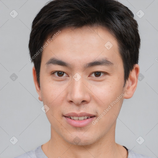 Joyful asian young-adult male with short  brown hair and brown eyes