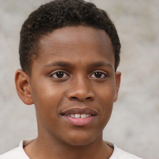 Joyful black child male with short  brown hair and brown eyes