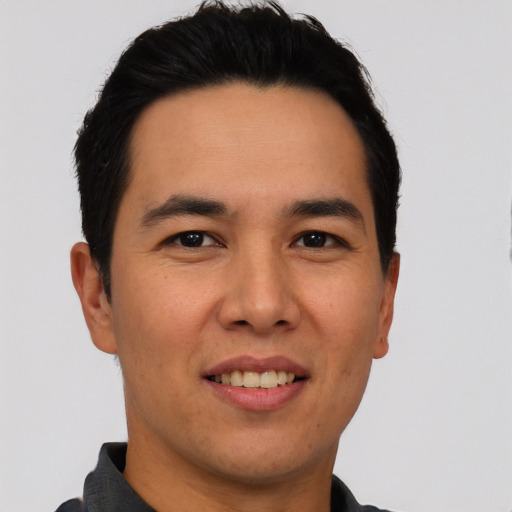 Joyful asian young-adult male with short  black hair and brown eyes