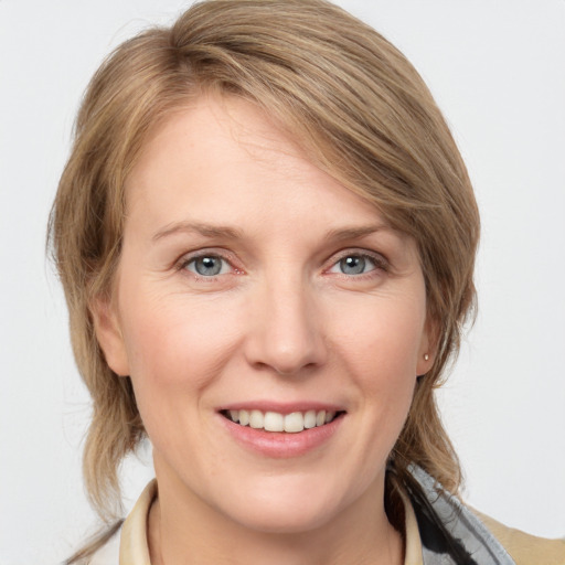 Joyful white young-adult female with medium  brown hair and blue eyes