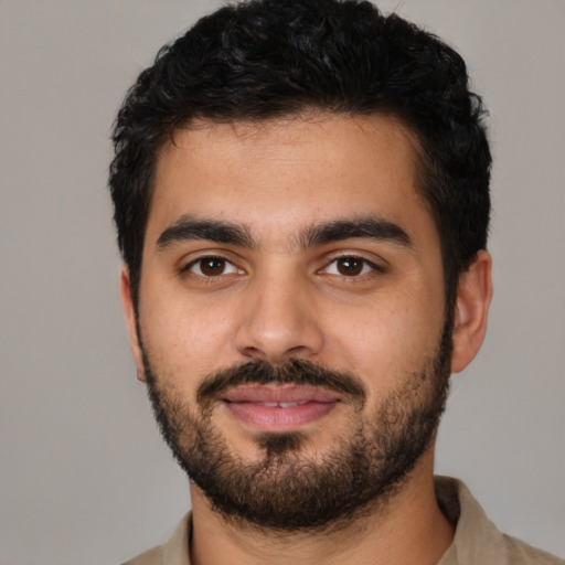 Joyful latino young-adult male with short  black hair and brown eyes